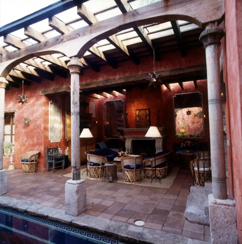 Salón integrado al patio con piscina, amueblado con equipales mexicanos.