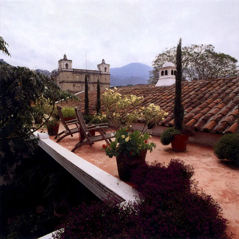 Azotea convertida en área social, con vista a las cubiertas en teja de barro y otras edificaciones de Antigua.