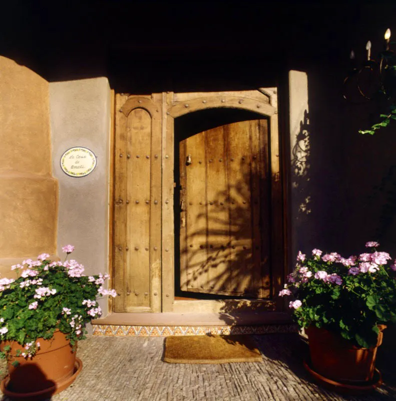 Entrada a una casa de recreo contemporánea a orillas del lago de Amatitlán, con puertas antiguas incorporadas.