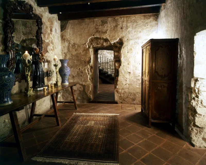 Detalles de la misma casa de Antigua, en los que se aprecia el uso de la baldosa de barro, los muebles de estilo colonial, los ornamentos variados y los muros originales que conservan su pátina y la huella del tiempo. Al fondo, la escalera contemporánea con baranda de hierro forjado.