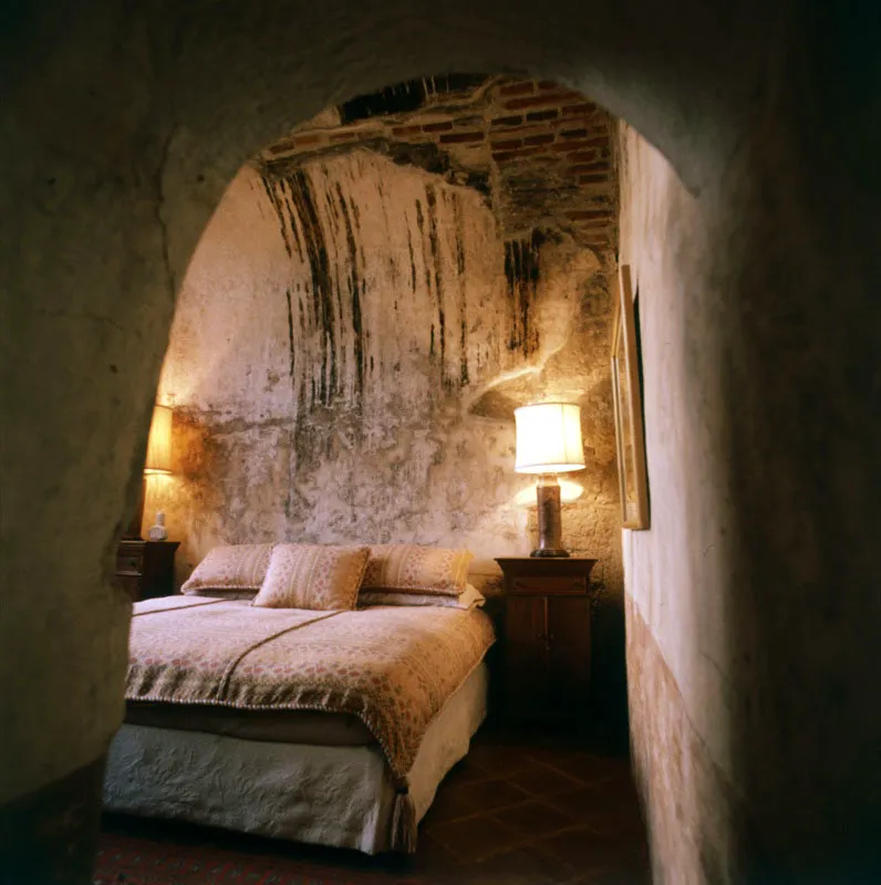 Dormitorio de la misma casa, restaurada en Antigua por el ingeniero Amerigo Giracca, adaptado a un espacio interior abovedado, con amoblado sencillo.