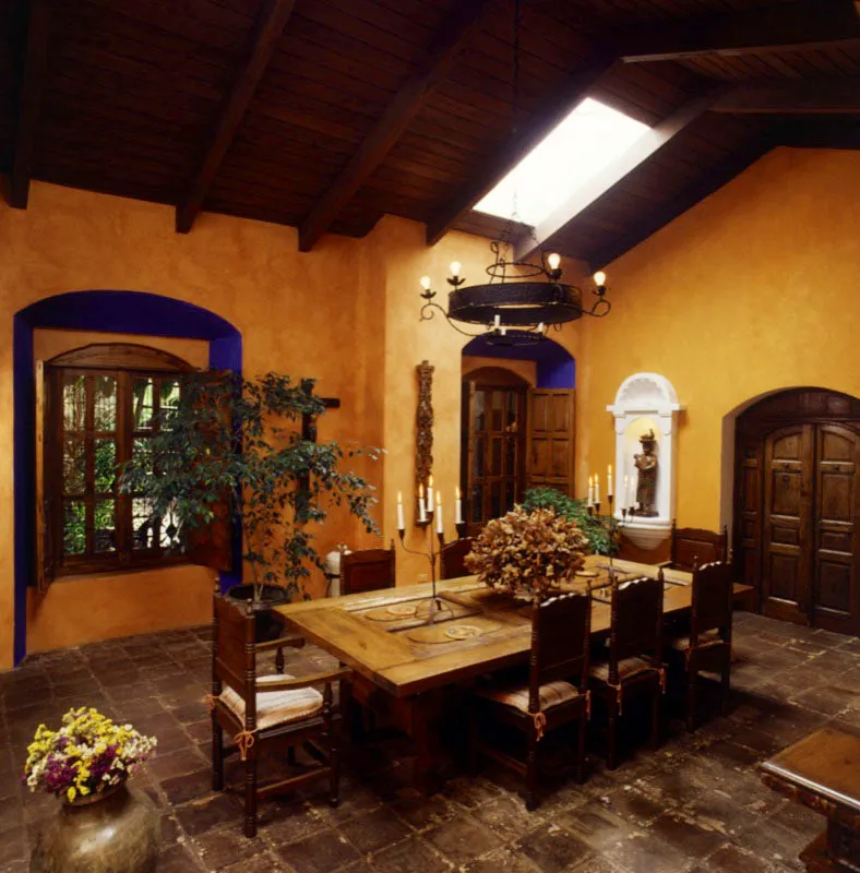 El comedor de la casa, de color naranja fuerte, decorado con un crucifijo popular y una pilastra de retablo que ya perdió su dorado; la ventana y la puerta resaltan por sus marcos en añil, lo mismo que la escultura popular de madera por su hornacina blanca. La mesa fue originalmente una puerta antigua tallada, adaptada al nuevo uso.