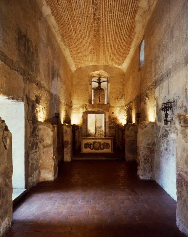 Parte de casa antigüeña, restaurada en forma de capilla, con techo abovedado, altar en madera tallada policromada y acondicionamiento de las bases de las columnas para iluminación indirecta.