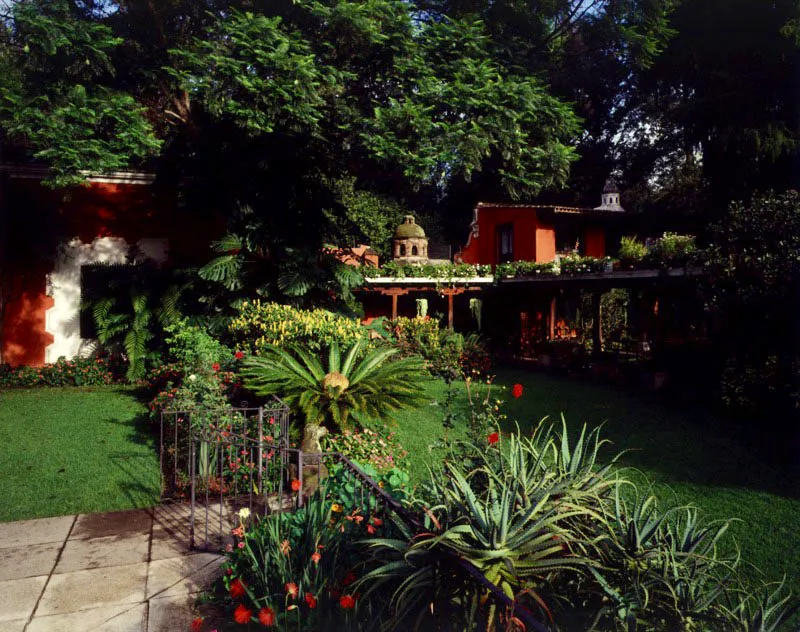 Amplio jardín de una casa contemporánea en Antigua Guatemala, que complementa una estructura colonial y utiliza elementos tradicionales de construcción, como el techo de teja de barro, los soportales y los tipos de ventanas. El jardín es un amplio muestrario vegetal, que aprovecha el clima y las posibilidades que en ese sentido da el valle de Panchoy.