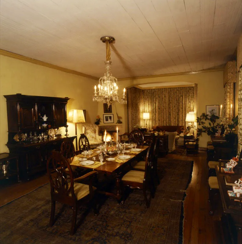Comedor de la misma casa en Cobán, con ambiente europeo y una pequeña sala de estar
al fondo. Tanto la mesa como el aparador fueron fabricados por carpinteros locales, la araña es de cristal de roca
y el piso de madera está cubierto por una gran alfombra persa antigua.