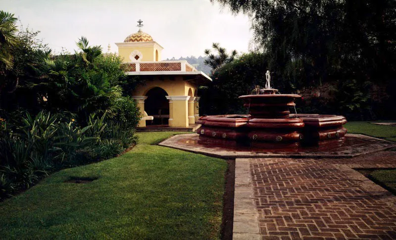 Amplio jardn de una casa en Antigua con fuente en estilo colonial. 