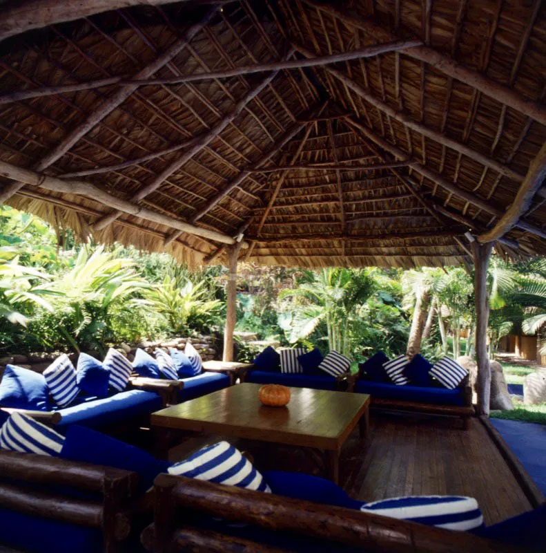 Del mismo rancho anterior, una terraza cubierta, con típico techo de manaco, amueblada con sillones tapizados en azul y blanco.
