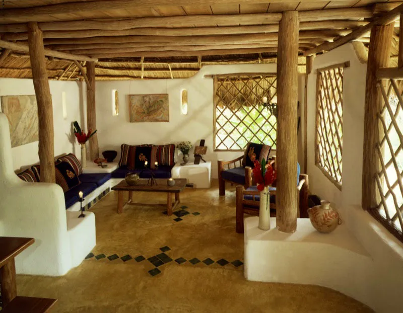 Otra casa de recreo tipo ranchón con techo de palma de corozo en Izabal, sobre la ribera del río Tatín, realizada por el decorador John Heaton. La sala, de gran luminosidad y ventilación con ventanas de delgados troncos entrelazados, se estructura alrededor de muebles de mampostería, recubiertos por cojines tapizados con textiles típicos guatemaltecos. El piso es de cemento teñido de amarillo con azulejos azules incrustados. Los cuadros son de la artista mexicana María Ruibalbo.