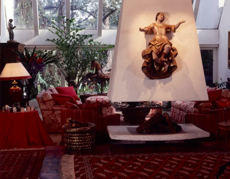 Aspecto de una casa contemporánea en las afueras de la ciudad de Guatemala. Una chimenea suspendida con un arcángel barroco policromado divide el corredor de una de las salas que se ilumina por amplios ventanales cenitales. El arquitecto de la casa es el guatemalteco Peter Giesemann.