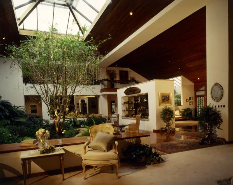 Casa contemporánea en la ciudad de Guatemala. Una elevada techumbre con tragaluz, debajo del cual hay un jardín, que sirve de sector central de distribución y conexión entre los varios ambientes del área social. Todo ello permite exhibir las pinturas y objetos de los muros, así como una vitrina, con vista de ambos lados, en la que hay algunas piezas prehispánicas mesoamericanas.