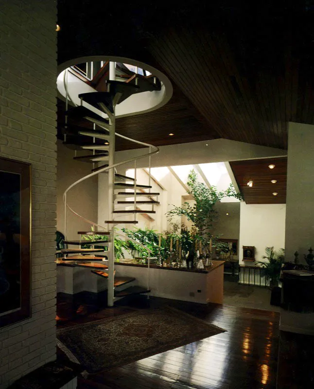 En la escalera volada de caracol se correlacionan la madera del piso, la de los escalones y la del techo, en un ambiente contemporáneo. Arquitectos Solares y Lara.