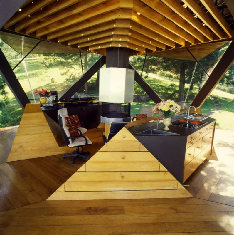 Casa de recreo contemporánea diseñada por al arquitecto José Asturias con vista al valle de Guatemala. El ingenioso sistema de abrir y cerrar triángulos permite adaptarse a las circunstancias de la luz y a los deseos de los ocupantes. Arriba, una pequeña sala con una chimenea en el centro y un lavabo y la cocina a la derecha, que sólo se aprecian cuando la casa se encuentra totalmente abierta. La chimenea y su base se pueden retractar a gusto.