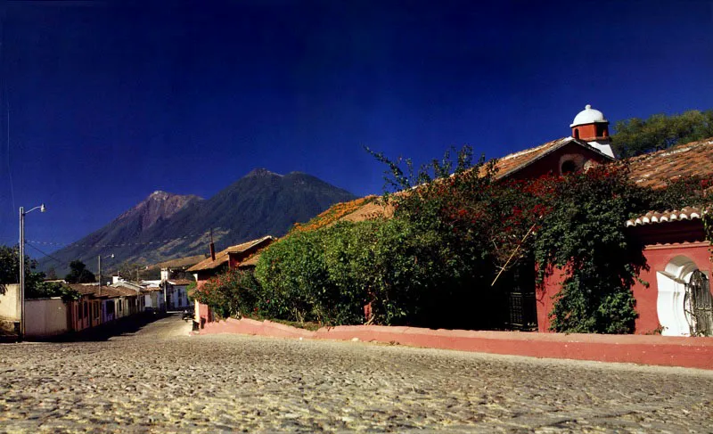 Calle colonial empedrada en la ciudad de Antigua. Al fondo los volcanes de Acatenango y Fuego. 