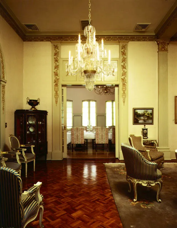 Vista desde la sala hacia el comedor de la residencia privada. A la izquierda, una vitrina esquinera estilo Luis XVI.