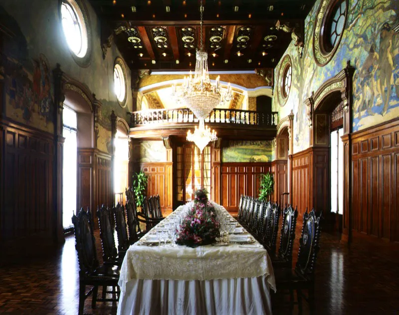 Comedor arreglado para una recepción. Los altos ventanales y las claraboyas dejan filtrar una luz amable.