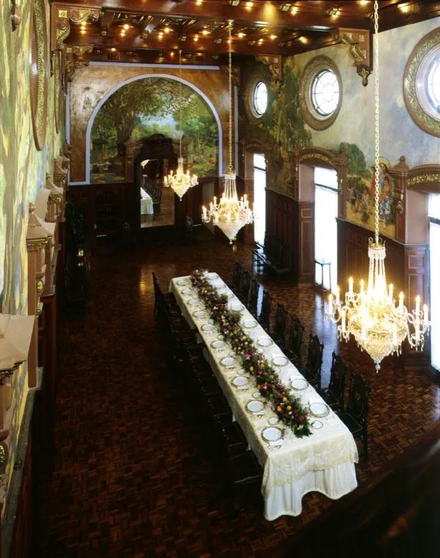 Comedor arreglado para una recepción. Los altos ventanales y las claraboyas dejan filtrar una luz amable.