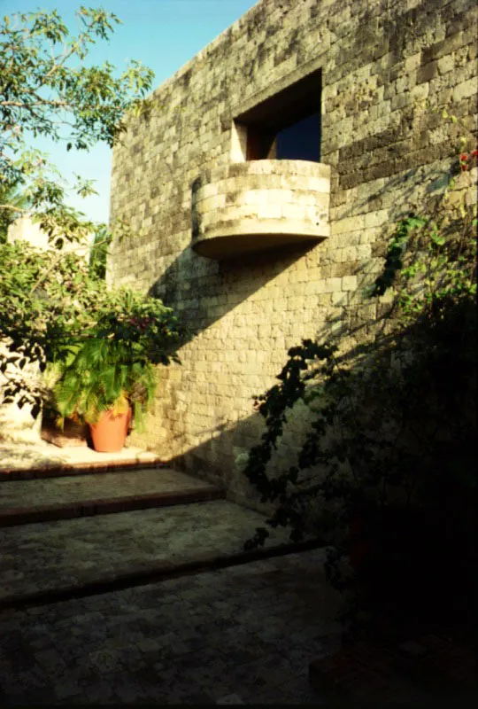 El balcón semicilíndrico de la sala de estudio, en voladizo, se proyecta sobre el patio del roble morado.