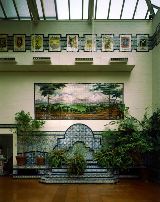 Este patio interior, diseado por Roberto Cueva del Ro autor de los murales est literalmente cubierto de azulejos de Talavera, fabricados en la ciudad mexicana de Puebla. Mientras la parte superior de los muros est decorada por los escudos de armas de los diversos estados mexicanos, la pila de agua remata en un paisaje que representa los volcanes Popocatpetl e Iztacchuatl que, como dicen los libros, han sido testigos silenciosos de la historia del valle de Mxico desde tiempos inmemoriales. Antonio Castaeda Buraglia