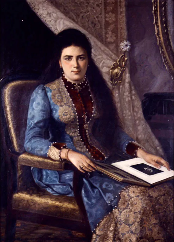 Eugenio Montoya. Mercedes Álvarez de Flórez, 1886.
Óleo sobre lienzo, 148 x 117 cm
Eugenio Montoya es reconocido en particular por la serie de retratos que, junto con Julián Rubiano y Constancio Franco, realizó a los próceres de la independencia, entre los que destaca el retrato de Dimas Daza, abanderado de Nariño. La importancia de estos retratos para la iconografía decimonónica es enorme. No obstante, la obra de Montoya se encuentra dispersa. En este retrato de Mercedes Álvarez de Flórez, que el artista expuso en el Salón de 1886, se aprecis una influencia determinante del academicismo francés. Montoya hace énfasis en la descripción del mobiliario, la decoración y el atavío de la retratada quien sostiene un álbum sobre sus piernas, asegurándolo delicadamente con sus manos, sin mirarlo. Su mirada se dirige directamente al pintor, aspecto que nos permite reconstruir el proceso de elaboración del retrato, al encontrarnos frente a la mujer, tal vez, en la posición en que la vio el artista.