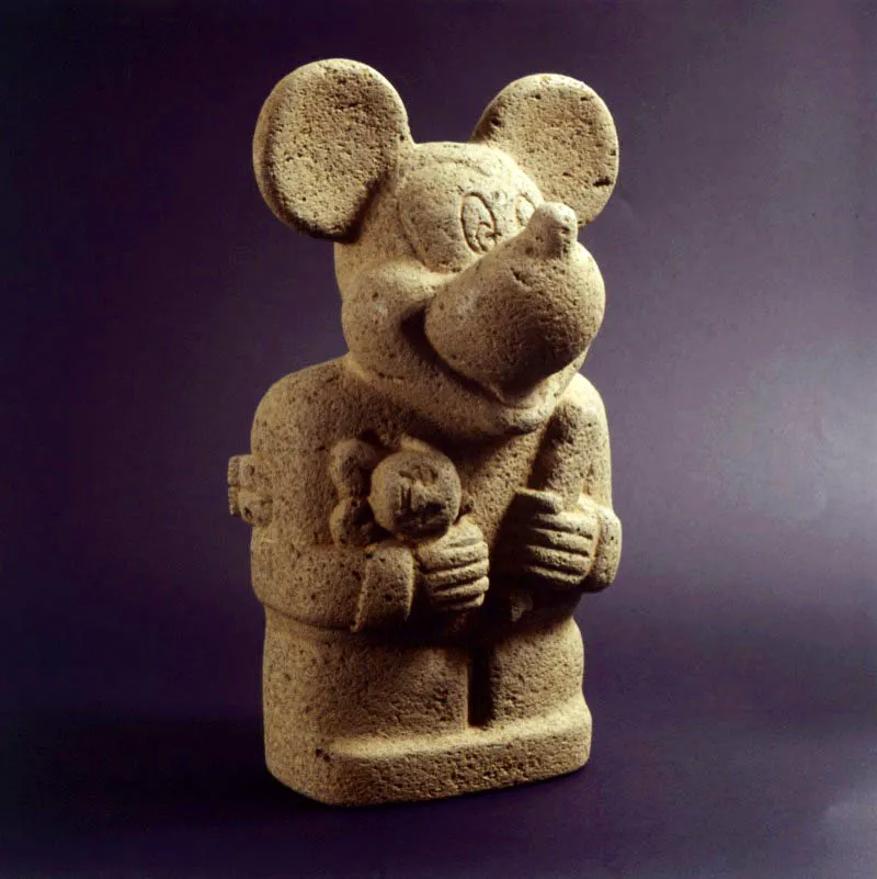 Nadn Ospina. dolo con mueca y cincel, 1999. 
Piedra, 31 x 17 x 14 cm 

La obra de Nadn Ospina (Bogot,1960) es una de las propuestas ms crticas e incisivas realizadas en Colombia alrededor de tpicos como la identidad nacional y la importancia de los conos que de manera simultnea la contienen y la configuran. En ella, Ospina realiza un ejercicio de yuxtaposicin de conos de culturas colombianas prehispnicas con conos de la cultura de masas. El resultado parece ser la encarnacin de una violenta penetracin de un elemento en el otro, imagen desconcertante que desconoce la naturaleza de los dos factores en relacin. En dolo con mueca y cincel, encontramos una fusin entre un monumento propio de la cultura San Agustn y el famoso ratn Miguelito de Walt Disney. El resultado es a la vez perturbador y ridculo, pero totalmente unificado: ambos elementos parecen haberse fusionado de manera irremediable. La obra de Nadn Ospina se cierra sobre s, entonces, convirtindose en una especie de cono de la actual nacionalidad colombiana. 