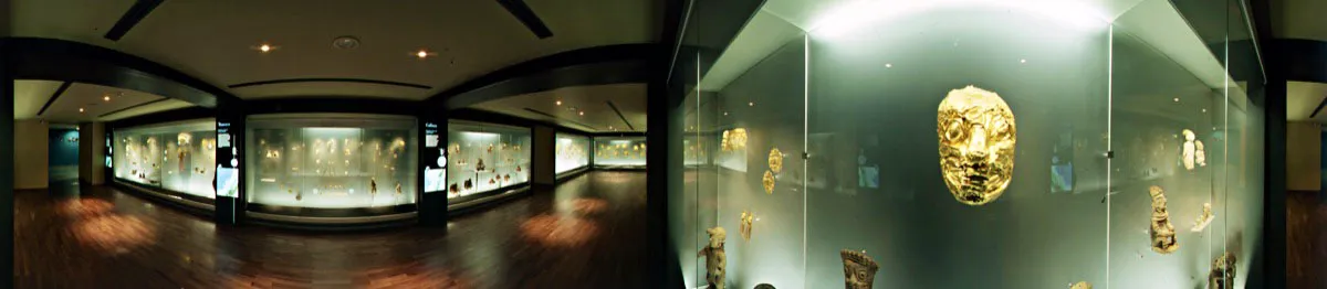 Sala “La gente y el oro en la Colombia prehispánica”. Vitrina de la costa pacífica, Tumaco, 700 a. C.-350 d. C. En primer plano, un mascarón de oro repujado. A sus costados, figuras antropomorfas de cerámica. Cristóbal von Rothkirch
