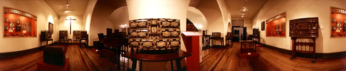 Gabinete de los Bargueños. En primer plano, escritorio “El bestiario”, en madera, marfil, hueso y carey. A la izquierda vitrina con objetos de arte religioso y cruz de madera del siglo xviii con incrustaciones. A la derecha, vitrina con miniaturas y bargueño con base de pie de puente. Cristóbal von Rothkirch