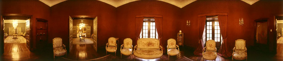 Sala de gabinete, forrada en damasco púrpura. Está decorada con apliques de cristal de Baccarat y mobiliario estilo francés tapizado en moqueta con motivos florales. A la derecha, una bandera de los Estados Unidos de Colombia, 1863. Cristóbal von Rothkirch