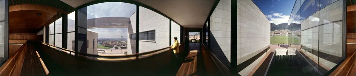 Rampa de acceso al área de servicios, que comunica el centro de documentación con la sala de exposiciones. A través de los ventanales puede verse el occidente de la ciudad y, en el extremo derecho, el barrio Belén y los cerros orientales. Cristóbal von Rothkirch