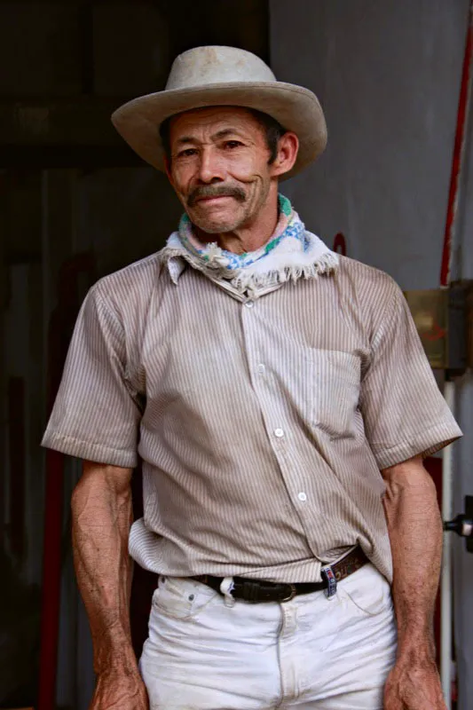 Si algo distingue a un campesino cafetero es el sombrero y la "mulera" un pañuelo de algodón que se utiliza para taparle los ojos a las mulas para cargarlas. Puede ser también un pañuelo raboegallo de vivos colores o simplemente una toalla. Los sombreros varían según la región, y el machete no puede faltar. Campesino cafetero de Palestina, Caldas. Carlos Pineda
