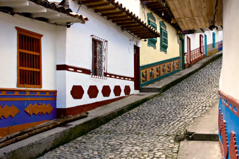Detalles de la iconografía cafetera que exhiben los zócalos de las paredes que dan a las calles empedradas de Guatapé, Antioquia. Carlos Pineda