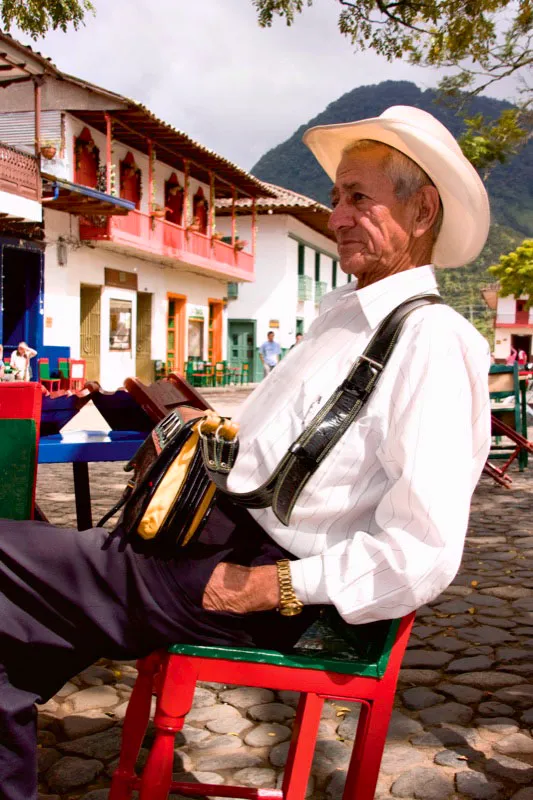 Todo antioqueo que se respete lleva terciado al hombro un carriel en donde guarda elementos tan variados como la navaja barbera, el tabaco, los dados y el naipe, el ojo de venado, la pepa de congolo y otros amuletos, las cuerdas del tiple y el yesquero, un escapulario y la novena de santa Genoveva, fsforos, ungüentos, adems de un poncho o mulera o el caracterstico pauelo raboegallo de vivos colores. Jardn, Antioquia. Carlos Pineda