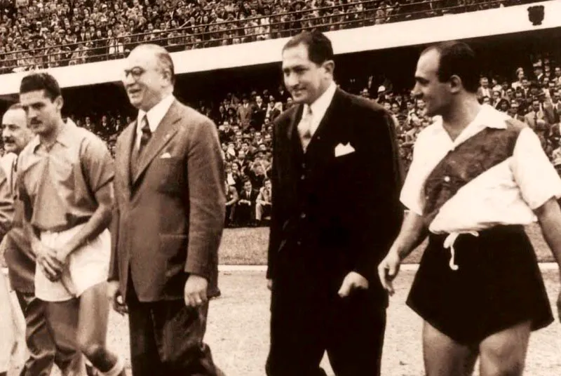 En enero, 1953, Millonarios, Santa Fe, Deportivo Cali, River Plate de Argentina y Rapid de Viena jugaron la Copa República de Colombia. Acto protocolario del partido Millonarios 1, River Plate 3: Francisco ‘Cobo’ Zuluaga, capitán del club local, con el embajador de Argentina, Alfonso Senior, y Norberto Yácono, capitán argentino.