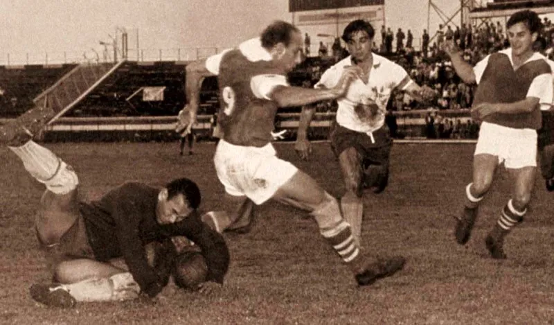 Julio 31, 1960. Partido Santa Fe 1, Medelln 0 en Bogot.
El Caimn Snchez, portero de Medeln, le quita el baln a Oswaldo Panzutto. Pcora y Perazzo esperan. 