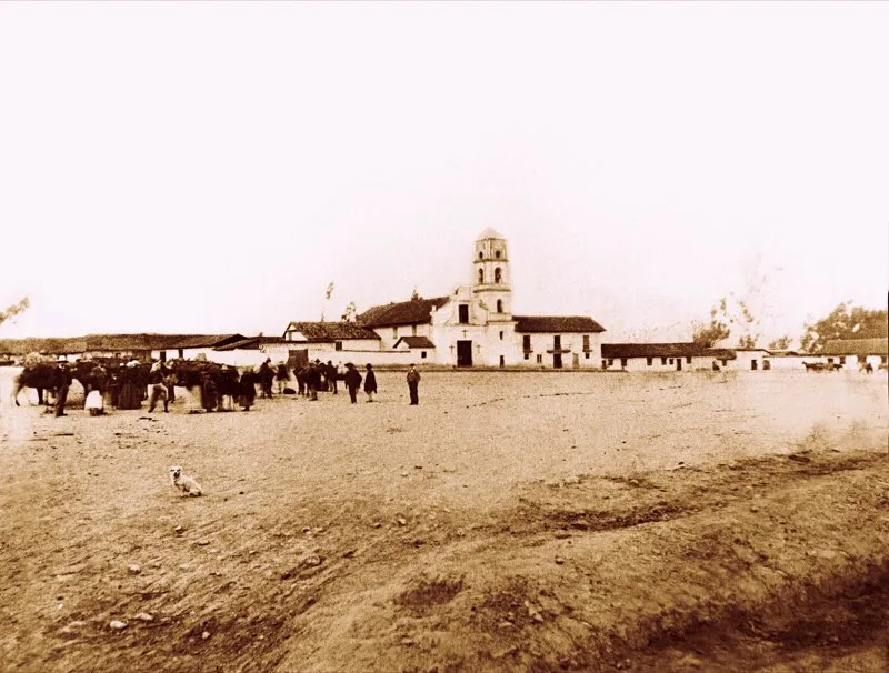 En las postrimerías del siglo xviii comenzó a levantarse en el extremo sur de la ciudad el barrio de Las Cruces, con una amplia plazoleta. En el curso del siglo xix Las Cruces fue pasando de barrio de pobres y humildes a zona de gentes acomodadas. Se construyeron cómodas y bellas residencias y una lujosa iglesia. En 1886 la plazoleta, que se encontraba muy deteriorada por el descuido de los vecinos y de las autoridades, fue entregada al ejército para que la arreglara y terraplenara, y se denominó plaza de Armas. Aunque el propósito era que el ejército la utilizara para ejercicios y entrenamiento, nunca se cumplió. En cambio se estableció, los días jueves, un activo mercado de artículos traídos de los pueblos del oriente —Choachí, Ubaque, Chipaque y La Calera— y cada año celebraban en Las Cruces concurridas ferias comerciales que llevaron gran prosperidad y abundancia a sus habitantes. Foto de Henry Duperly, 1880.