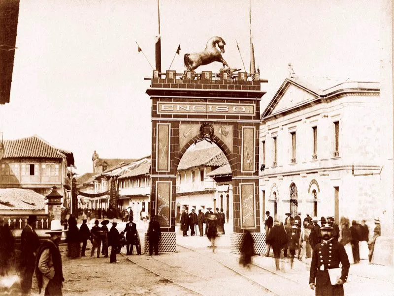 Tras la victoria de las tropas del gobierno en Enciso en abril de 1895, que puso fin a la guerra empezada en enero de ese año, se levantó un arco triunfal en Bogotá para recibir al ejército victorioso del general Rafael Reyes, proclamado héroe nacional. El arco estaba ubicado en la entrada sur del puente de San Francisco, carrera 7.ª con calle 15. Foto de Henry Duperly.