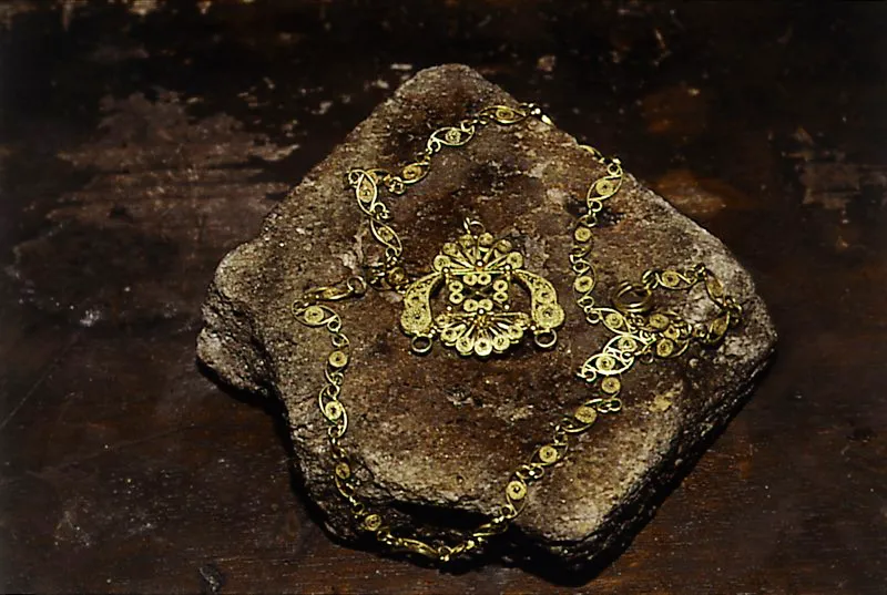 Collar en oro con incrustaciones en piedras preciosas. El tejido ha sido trenzado con hilos en oro retorcidos. Con la técnica de la filigrana se diseñan pétalos de flores, alas de mariposas, formas geométricas, cuentas para collar, pulseras, anillos, aretes o zarcillos. La producción orfebre de esta región es una de las más auténticas y de más antigua tradición, donde se trabaja con oro de buen quilataje y mínimo porcentaje de plata o cobre. Barbacoas. Nariño.
Diego Miguel Garcés