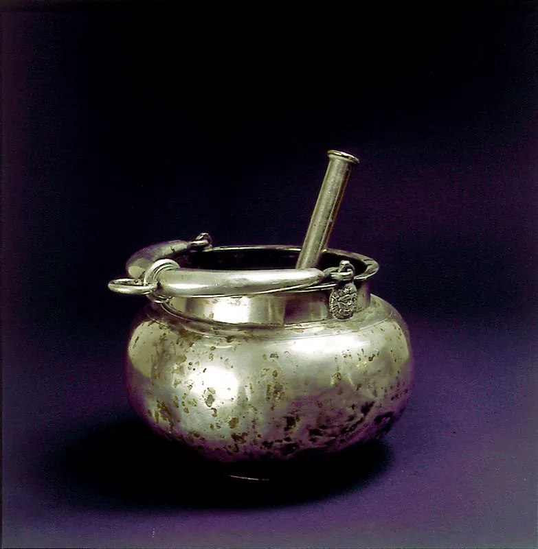Acetre e hisopo para el uso religioso del agua bendita. Elaborado en plata fundida, martillada y labrada, con relieve zoomorfo en la base del asa. Siglo XVIII. Popayán, Cauca. José Fernando Machado