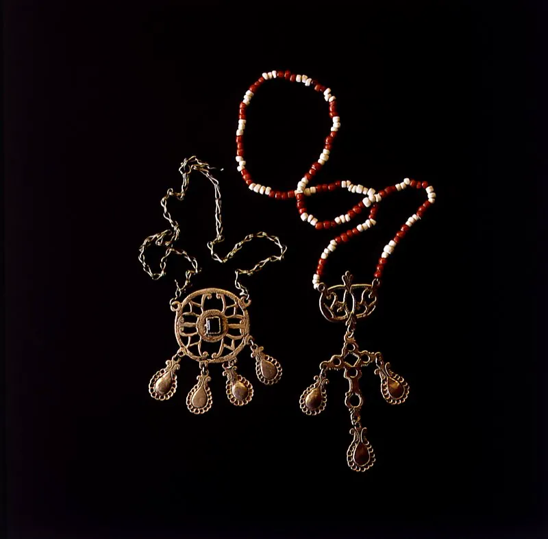 Collares o “cruceros” en plata fundida, con incrustaciones de piedras semipreciosas, elaborados por indígenas Guambiano. El mestizaje de los diseños deriva de la fusión de culturas y creencias. En ellos se han conservado el sentido de la belleza y la tradición del arte orfebre prehispánico. En materiales semejantes a los utilizados en la Colonia, los Guambiano se adornan con zarcillos y alfileres metálicos. Silvia, Cauca. José Fernando Machado