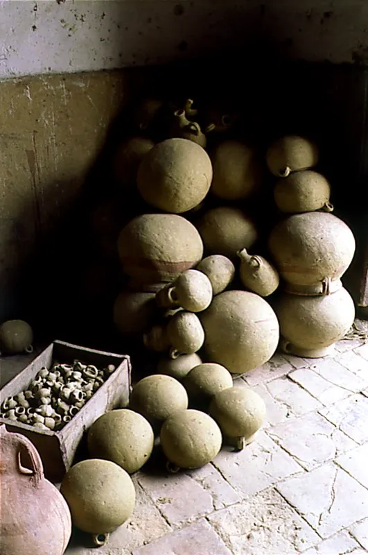 Recipientes cerámicos almacenados durante el proceso de secado. Después de moldeadas y antes de ser llevadas al horno, las vasijas deben secarse al aire. Este es el momento en el que los artesanos les dan a sus piezas un tratamiento especial, de acuerdo con el uso para el cual están destinadas. Algunos las aliñan, les añaden las orejas y las emparejan con pedazos de totuma para reducir la porosidad. Cada pieza, cuando está blanqueada y seca, se moja, se pule, y luego se pinta. Se aprecia también un cajón con cerámicas más pequeñas, conocidas como “maíz tostao”, que contiene loza, pitos y animales. Estos objetos son posiblemente herencia de la cerámica ritual Chibcha. Actualmente, son adquiridos por los peregrinos como recuerdo de sus visitas a santuarios religiosos. Familia Rubiano. Ráquira, Boyacá. Diego Miguel Garcés