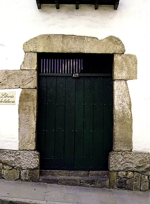 Portada en piedra de cantera tallada. El jambaje que rodea puertas y ventanas de la poca colonial, es variado, tanto por la forma como por la calidad del material. Las portadas, compuestas por dos pilastras sobre las que se colocaba una cornisa, se fabricaban, generalmente, de adobe y ladrillo. Slo en las casas de familias prestantes, se ejecutaban en piedra. El dintel, constituido por un bloque de piedra de forma rectangular, se sostena sobre jambas o columnas verticales, a uno y otro lado. Bogot Jos Fernando Machado