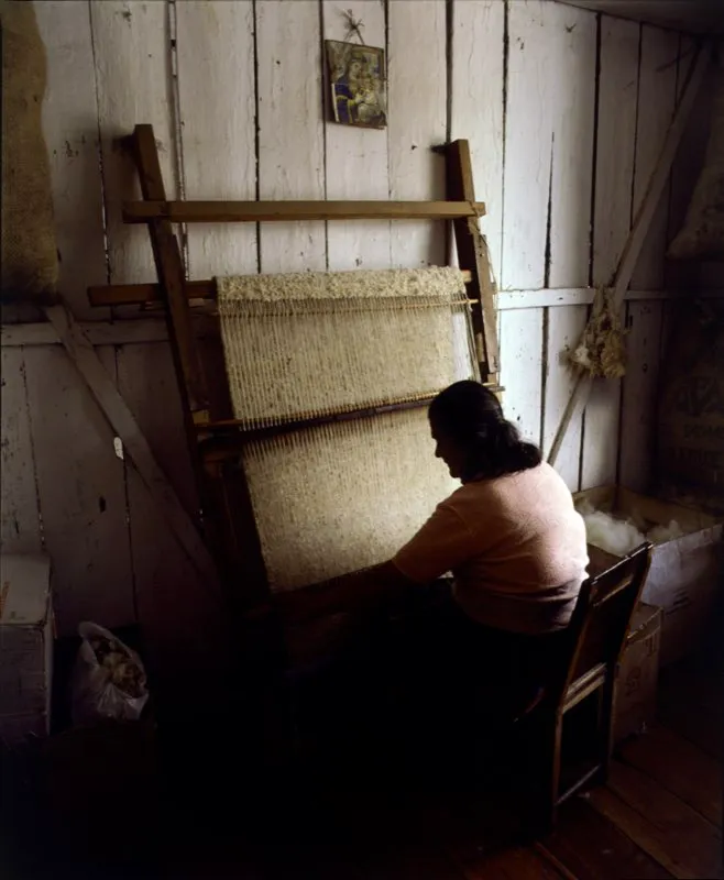 Mujer tejiendo paño de lana para una ruana, sobre telar vertical. En las zonas rurales del altiplano andino son bastante comunes los telares rústicos en las casas. Santa Rosa, Santander. Jorge Eduardo Arango