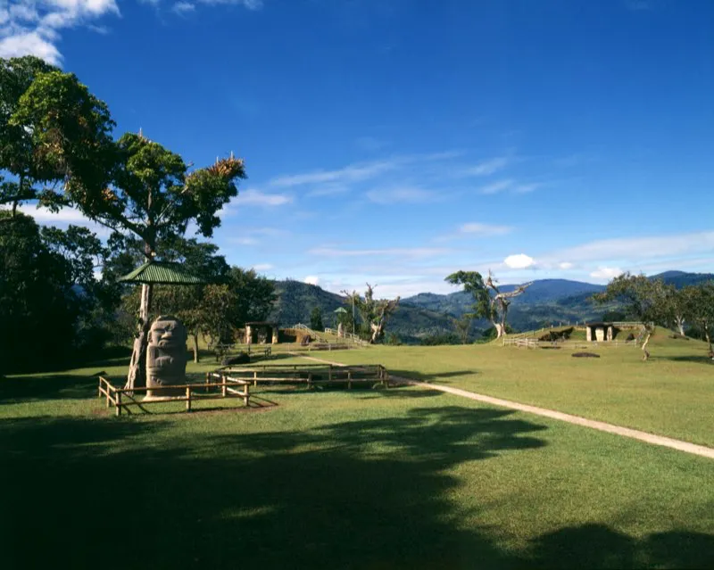 Vista general de la Mesita A del Parque Arqueológico de San Agustín. Las altas montañas que rodean los valles de San Agustín e Isnos bien pudieron haber sido importantes “en la defensa de sus primitivos moradores contra pueblos enemigos”, como observó el arqueólogo Luis Duque Gómez. Con menos pragmatismo, un siglo antes de él el geógrafo Agustín Codazzi vio a la región como un territorio “separado del resto de la tierra como un santuario misterioso, y aún podría decirse que invigilado por las moles estupendas que, cual centinelas de la eternidad, se levantan a su alrededor”. Las estatuas y las tumbas en medio de aquel ambiente de umbrosos valles, profundos precipicios e inverosímiles cascadas inevitablemente dejan en muchos visitantes, como dejaron en Codazzi, la sensación de que aquel es un mundo mítico y mágico.