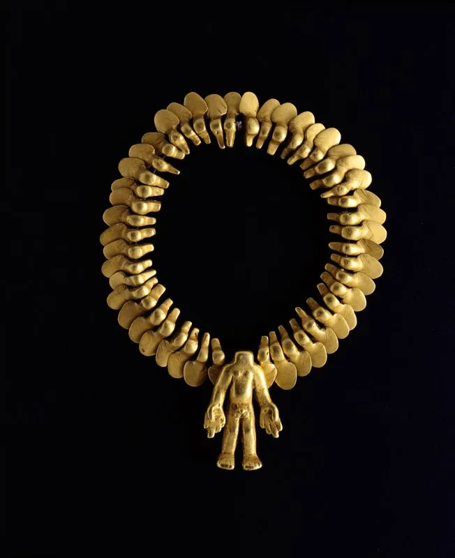 Collar de cuentas elaborado mediante la técnica de la cera perdida, cuya figura central es un hombre sin cabeza y con desmesuradas manos (Museo del Oro, Bogotá). Aunque el hallazgo en “basureros” de gotas de oro fundido, trozos de alambre y otros restos atribuibles a talleres orfebres son evidencia de que la metalurgia se practicó en el Macizo Colombiano, el corto número de piezas encontradas y la dificultad de identificar un estilo propio de la región parecen poner en duda que la orfebrería hubiera tenido allí un desarrollo similar al de otras áreas arqueológicas de Colombia. Lo que parecen sugerir objetos como este y otros aún más refinados descubiertos en tumbas de San Agustín e Isnos parece ser la circulación de bienes culturales entre esta y otras regiones en las épocas en que se labraron las estatuas.