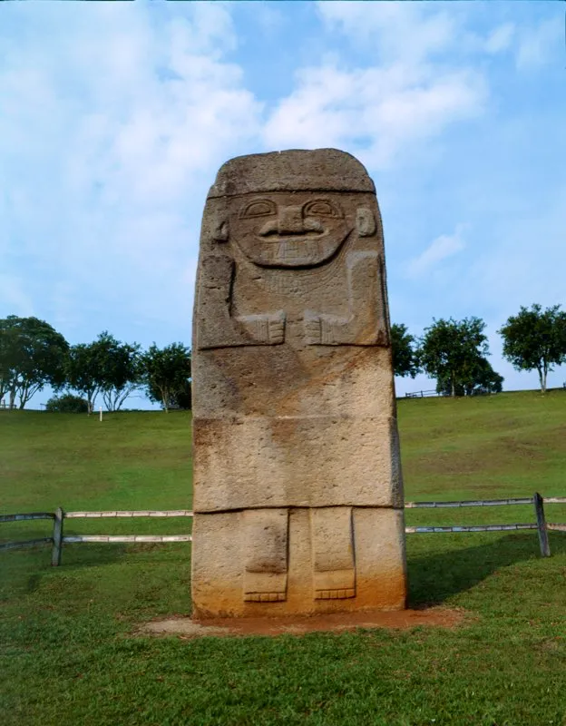 La mayor estatua del Macizo Colombiano está localizada en medio del terraplén que une las dos mesetas del Alto de los Ídolos. Está labrada en una placa de más de cinco metros de altura, 1,75 m de anchura y sólo 23 cm de espesor. La rusticidad de los detalles y la falta de tridimensionalidad despojan a esta escultura de la fuerza expresiva de las demás estatuas, impresionando casi exclusivamente por su gran tamaño.
