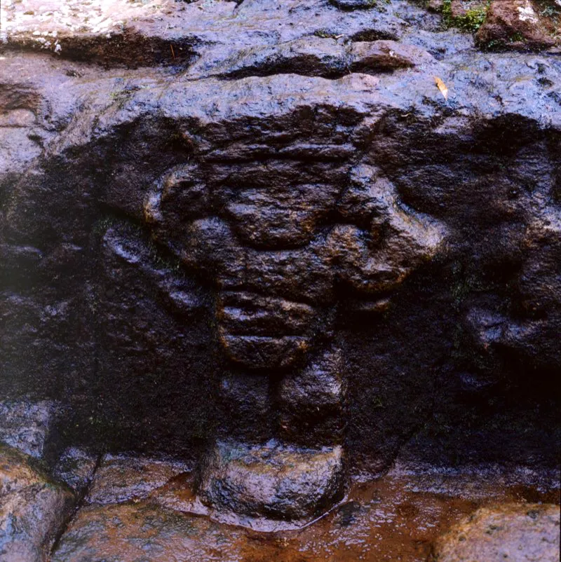 Imagen masculina con corona de plumas en el estanque principal de la fuente de Lavapatas, con la particularidad —única en el Macizo Colombiano— de que muestra los brazos levantados.