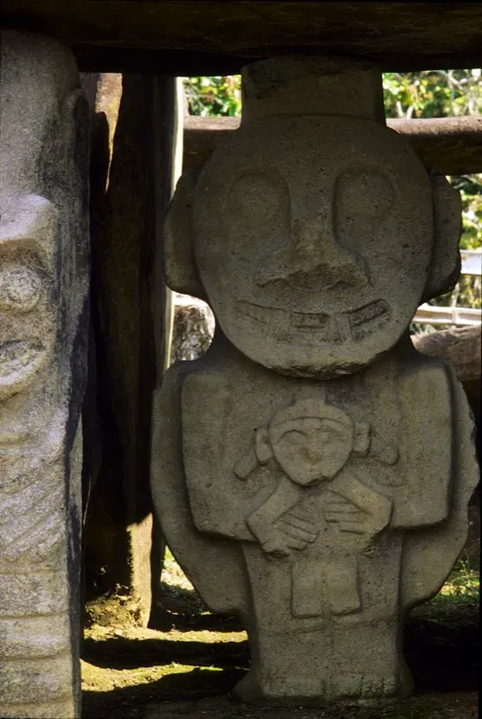 Figura infantil sostenida en su regazo por un adulto; combina las técnicas del relieve tridimensional (rostro) y el relieve biplano.