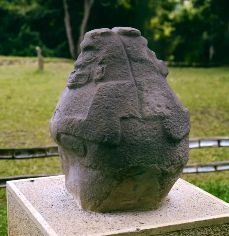Curiosa estatua bifronte de la Mesita C del Parque Arqueológico de San Agustín. Muestra dos figuras simiescas unidas por la espalda que constituyen la expresión más acabada de escultura de bulto redondo en la estatuaria. Sus dos frentes principales no son absolutamente idénticos y podría pensarse que uno de ellos, o quedó inconcluso, o representa una faceta contraria de cierto mensaje, pues faltan las fauces animales.