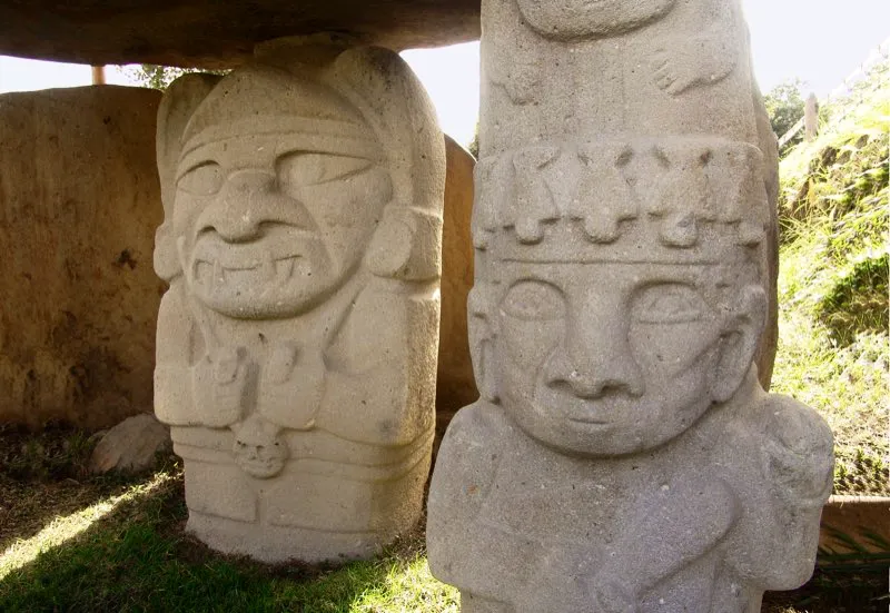 Dos de las estatuas del Montículo Noroeste de la Mesita B del Parque Arqueológico de San Agustín. La figura del primer plano, una de las más realistas de toda la estatuaria, se ha descrito como un “guerrero” por el arma que lleva en la mano derecha. La del fondo se ha visto como la imagen de un chamán con un “cráneo trofeo” pendiente de su cuello. Pero estas afirmaciones generales solo dejan más preguntas que respuestas.