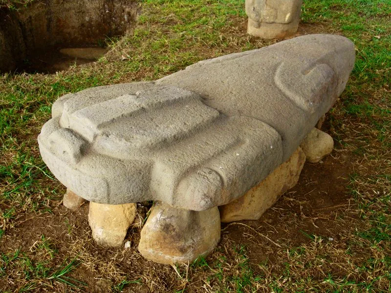 La dificultad de describir muchas estatuas se aprecia una vez más en lo que se ha dicho sobre esta escultura del Alto de Lavapatas, tallada en una placa triangular. Konrad Preuss la vio como “un animal echado, o más bien acurrucado, de manera poco natural, que quizá representa un perro”, y aún hoy es para muchos un “perro echado”. Luis Duque Gómez, por su parte, pensó que se trataba de una “rana”.