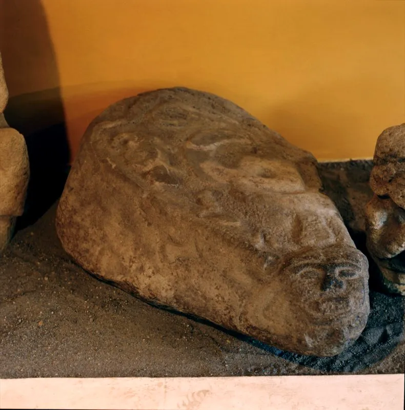 Piedra de 120 centímetros de largo que se encontraba originalmente en la pendiente de la Mesita B a la quebrada de Lavapatas, en el Parque Arqueológico de San Agustín. En una de sus puntas tiene una cara de mono (o humana con fauces animales), en su parte superior una serpiente y otros motivos ofidiformes, y en uno de sus cantos la figura de un lagarto cuya cola, exageradamente larga, rodea el conjunto.